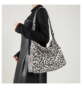 Close-up of a large leopard print canvas shoulder bag with an adjustable strap