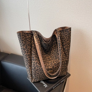 Fashionable autumn velvet tote bag with leopard print on a luxury sofa setting