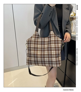 Close-up of brown and white checkered canvas tote bag with adjustable shoulder straps