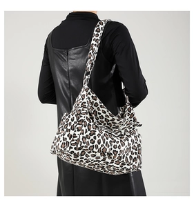 Detail view of large capacity leopard print tote bag worn as a shoulder bag