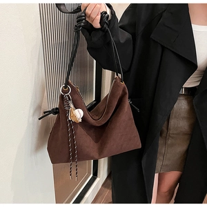Détail du sac bandoulière en daim marron foncé avec poignée en corde et fermeture
