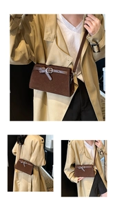 Detail view of deep brown vintage matte crossbody bag with metal buckle and strap