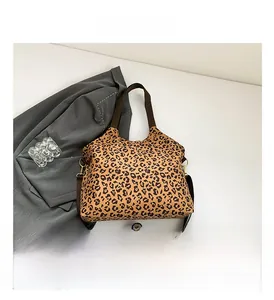 Detailed view of leopard print canvas tote bag with adjustable brown shoulder straps