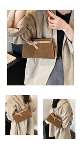 Detailed view of dark brown frosted leather texture and metal buckle on square bag