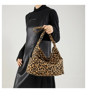 Close-up of leopard print hobo bag showing thick canvas texture and side pocket detail