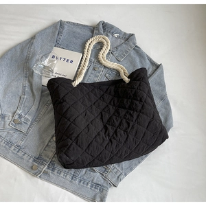 Fashionable black quilted tote bag with white cotton rope handles for autumn styling