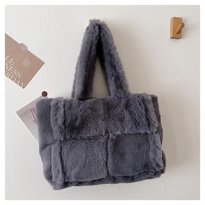 Détail du sac à main gris en fausse fourrure tressée avec une texture pelucheuse douce