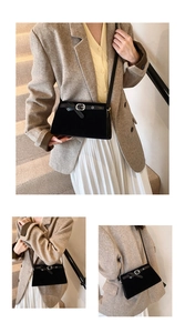 Close-up of vintage black suede crossbody bag featuring elegant silver metal buckle detail