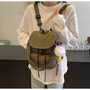 Détail d'un sac à dos en nylon vert armée avec broderie Trick or Treat et breloque peluche