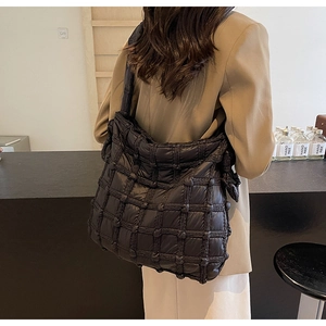 Sac fourre-tout matelassé noir à la mode porté par un mannequin en tenue d'automne