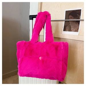 Gros plan sur un sac cabas en peluche fuchsia avec grand tissage matelassé et nœud