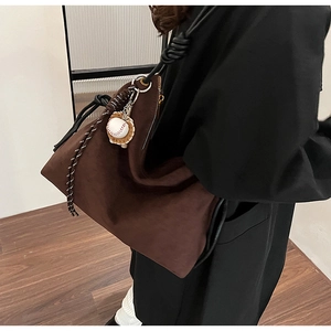 Sac fourre-tout en daim marron avec bandoulière nouée et breloque baseball à l'épaule