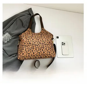 Top view of a leopard print tote bag with tablets showing size comparison for daily commute