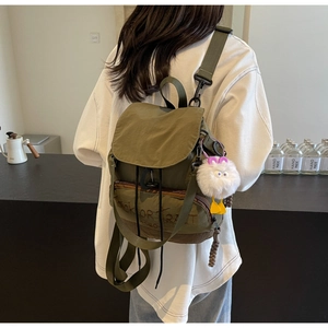 Détail du sac à dos en nylon vert militaire avec broderie et pendentif peluche