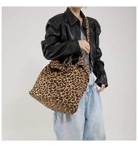 Detailed view of leopard print canvas tote bag with wide strap on model