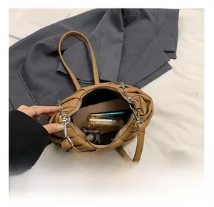 Detailed view of spacious interior of brown pleated PU leather bag with daily essentials