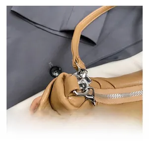 Close-up of litchi grain brown leather bag featuring silver metal zipper and hardware