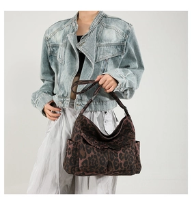 Detail of leopard print hobo bag with wide shoulder strap and side pockets for casual use