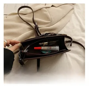 Detail view of the small vintage crossbody bag interior showing storage for cosmetics