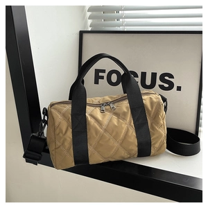 Minimalist khaki nylon quilted cylinder handbag with wide black straps and crossbody option
