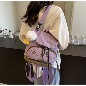 Détail d'un sac à dos en nylon violet clair avec broderie et breloque en peluche