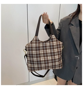 Detailed shot of retro plaid tote bag with brown fabric handles and adjustable strap