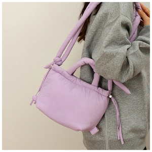 Detail of light purple padded nylon tote bag featuring puffy quilted texture and straps