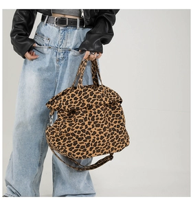 Close-up of leopard print canvas tote bag featuring crossbody strap and soft texture