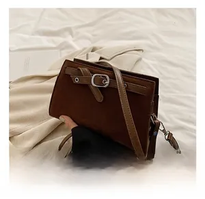 Detailed macro view of dark brown faux suede texture and buckle on minimalist crossbody bag