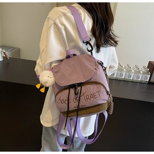Détail d'un mini sac à dos violet avec broderie Halloween et pendentif peluche