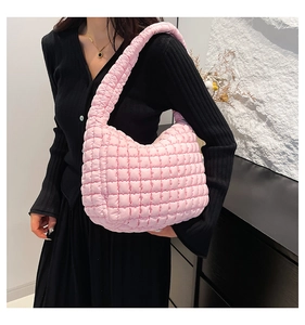 Pink quilted bubble hobo bag with textured puffy fabric shown on a model's shoulder