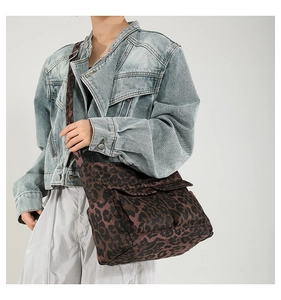 Detail of leopard print messenger bag with double front flap pockets and wide strap