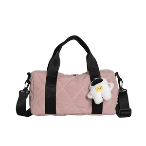 Pink quilted nylon barrel bag with astronaut charm and black detachable shoulder strap