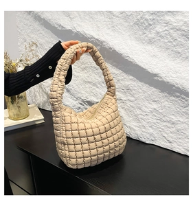Close-up of beige quilted bubble bag with padded lattice texture and zipper detail