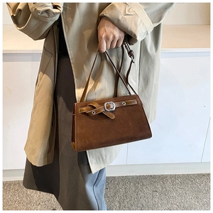 Detail view of a vintage dark brown matte leather crossbody bag with metal buckle strap accent
