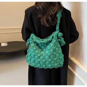 Détail d'un sac à bandoulière en tissu matelassé vert vif avec une texture bouffante unique