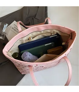 Intérieur spacieux du sac cabas rose à imprimé cerise avec plusieurs poches de rangement