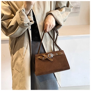 Detailed close-up of dark brown vintage shoulder bag with matte finish and metal buckle