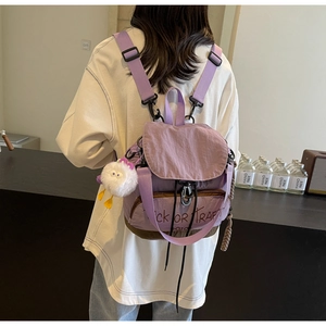 Détail d'un sac à dos en tissu violet avec base marron et imprimé Trick or Treat et peluche