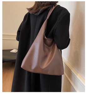 Minimalist dark brown litchi grain PU leather tote bag shown on model's shoulder