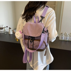 Détail du sac violet en nylon multifonction avec cordon, boucle et breloque poussin blanc