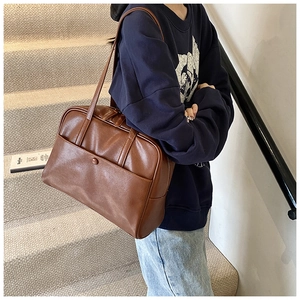 Detailed shot of a vintage brown PU leather tote bag with a functional buckled front pocket