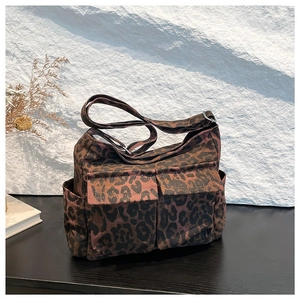 Fashionable leopard print canvas shoulder bag with front flap pockets and adjustable strap