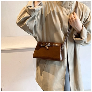 Detail of a brown vintage crossbody bag with metal buckle and adjustable strap