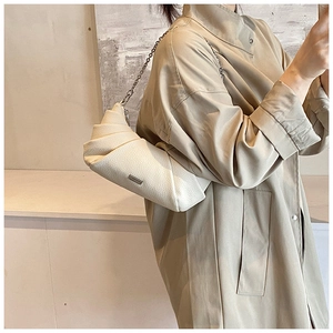 Detail of off-white pleated cloud bag with silver chain strap and leather texture