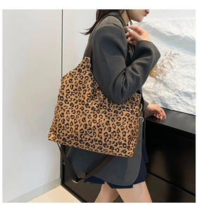 Chic leopard print canvas tote bag with brown straps styled on a fashion model