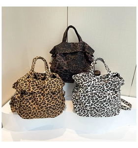 Detailed view of three leopard print canvas tote bags in brown, tan, and cream colors