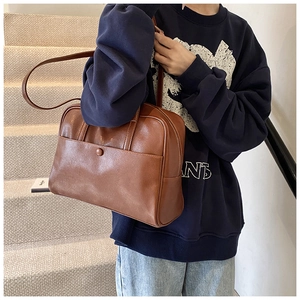 Classic brown PU leather tote bag shown being worn over the shoulder in a casual setting
