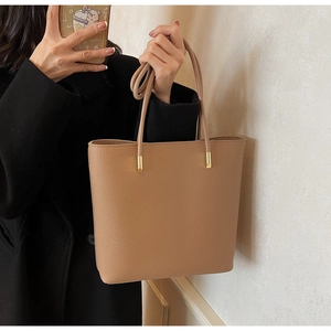 Detail view of khaki PU leather tote bag with lychee texture and gold hardware accents