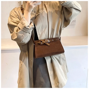 Detail of vintage brown crossbody bag with matte texture and decorative belt buckle strap